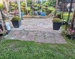 Tuinposter Een weelderig groene tuin met levendige bloemen en bomen rond een rustige vijver